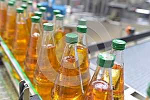 Apple juice in glass bottles in a factory for the food industry - bottling and transport