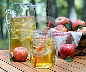 Apple juice in glass and pitcher with fresh apples