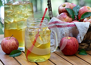 Apple juice in glass and pitcher with fresh apples