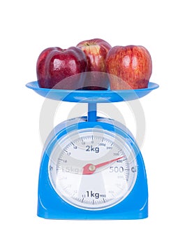 Apple on kitchen scale isolated on white background