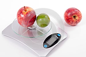 Apple and lemon on kitchen scale