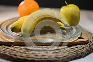 Apple and orange bananas on a glass tray for dessert photo