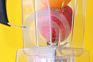 Apple and orange in a blender close-up. The blender knife is ready to go. Healthy eating photo