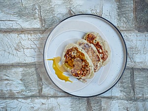 Apple pancakes with fruit honey on a light plate