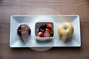 Apple, pear, strawberry and grape on the white bowl