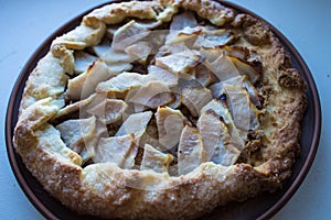 A apple pie on a clay plate on white background