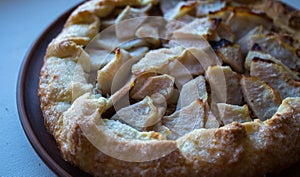 A apple pie on a clay plate on white background
