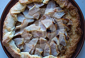 A apple pie on a clay plate on white background