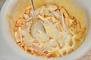 Apple pie dough preparation in a bowl and a spoon close-up