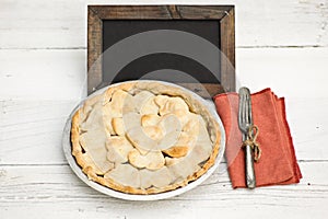 Apple pie with heart shaped crust topping with chalkboard