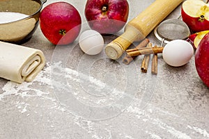 Apple pie ingredients baking concept. Fresh apples with cinnamon, flour, sugar, eggs. Cooking process on stone background, top
