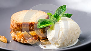 apple pie on plate with a scoop of vanilla ice cream