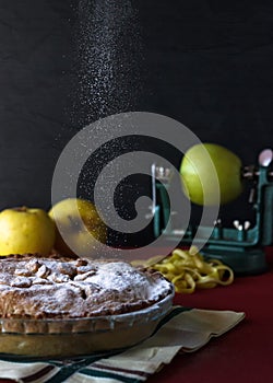 Apple pie with sugar rain. Black background with apples.