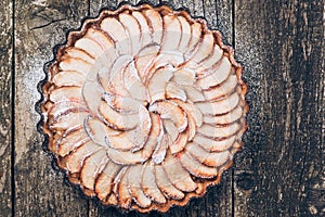 Apple pie tart on rustic wooden background. Ingredients - apples and cinnamon .Top view.