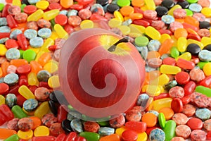 apple on pile of assorted candy background