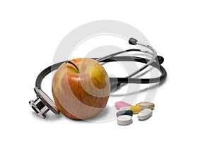 Apple with pills and a stethoscope