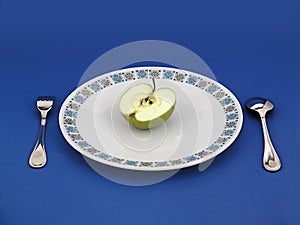 Apple on plate with silverware