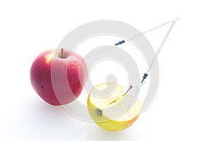 Apple with punched needles and syringes as a concept for modified food white background