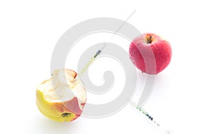 Apple with punched needles and syringes as a concept for modified food white background