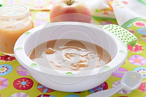 Apple puree in bowl on colorful tablecloth