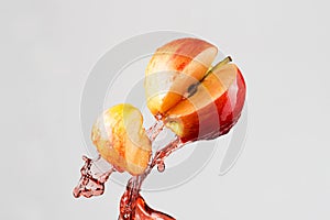 Apple and red juice splash isolated on a gray background