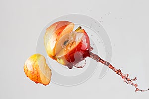 Apple and red juice splash isolated on a gray background