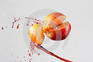 Apple and red juice splash isolated on a gray background