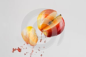 Apple and red juice splash isolated on a gray background