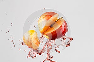 Apple and red juice splash isolated on a gray background