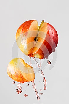 Apple and red juice splash isolated on a gray background