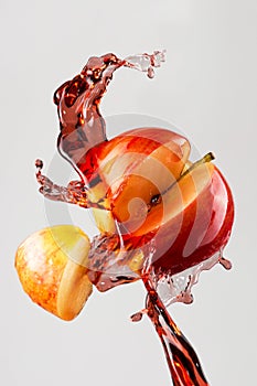 Apple and red juice splash isolated on a gray background