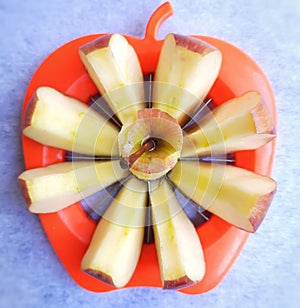 Apple shown beautifully in apple cutter looks like flower shape and it tempts to eat in white background