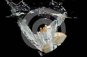 Apple slice splashing in the water.