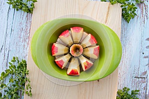 Apple slicer with red apple cutted into eight pieces on cutting board