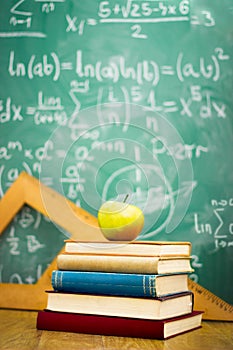 Apple on stack of books with chalkboard