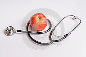 Apple and stethoscope isolated on white