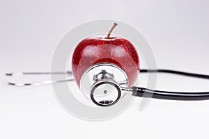 Apple and stethoscope isolated on white