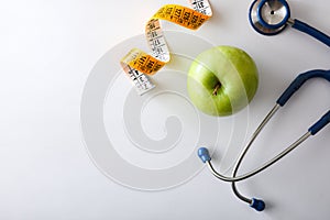 Apple stethoscope and tape measureon white table top view