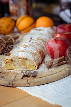 Apple strudel with fresh apples and cinnamon on a wooden board