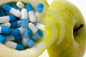 Apple with tablets capsules.