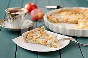 Apple tart with cup of tea and whole apples