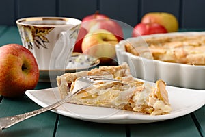 Apple tart with cup of tea and whole apples