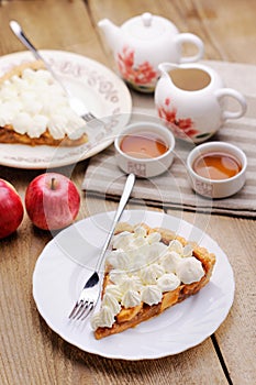 Apple tart with whipped cream, red apples and teaware