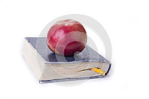 Apple on top of the old book on the white.