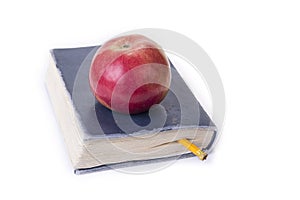 Apple on top of the old book on the white.