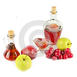 Apple vinegar and wine in glass bottle and ripe apples and grapes isolated on white. There is free space for text. Collage