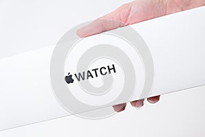 Apple watch box in woman hand on the grey background with copy space, December 2020, San Francisco, USA
