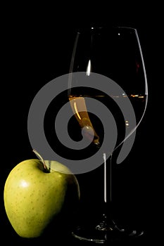 Apple and wine glass with juice on black photo