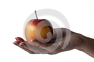 An apple in a woman`s hand, offering an apple to someone photo