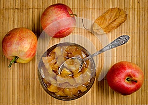 Apples and apple jam in a vase with a spoon